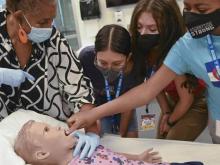 SARSEF campers practice a procedure on Hal, the pediatric patient simulator