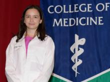Sydney Phan in front of a College of Medicine - Tucson banner